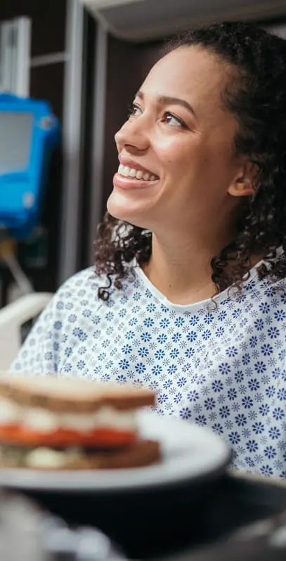 Smiling hospital employee enjoying a meal in the cafeteria