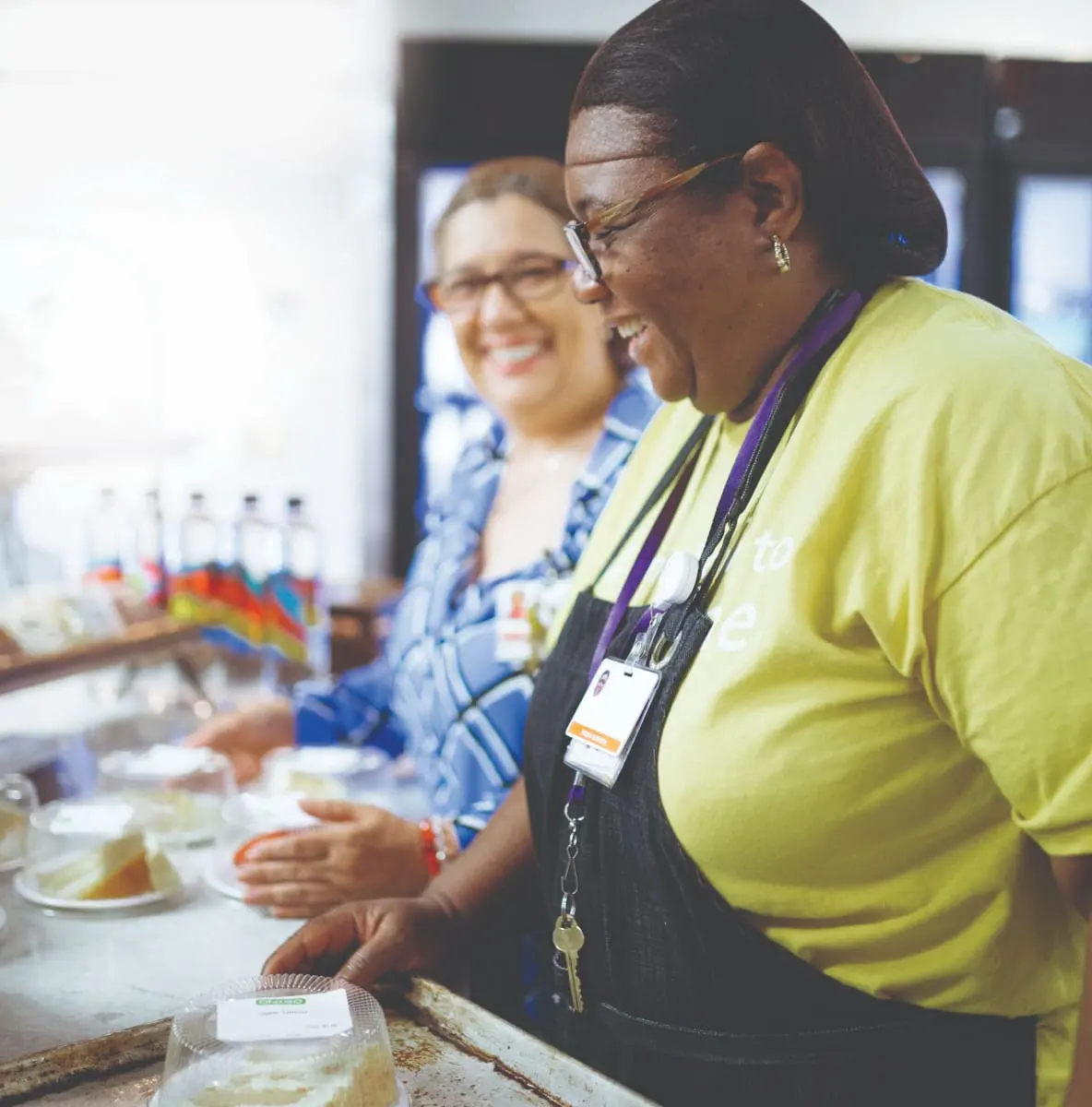 Morrison Healthcare team members smiling while serving food in a cafeteria setting
